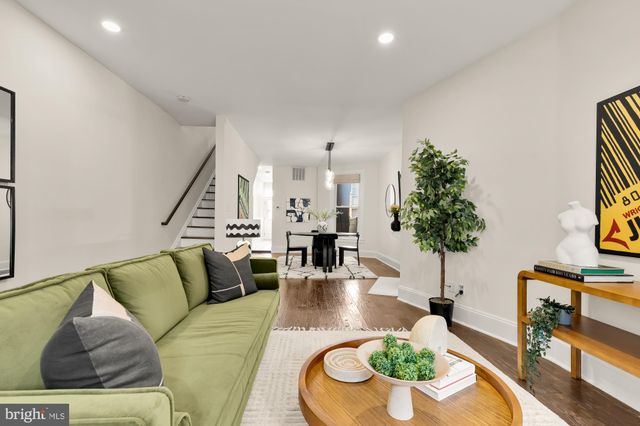 a living room with furniture potted plant and a large mirror