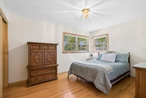 a bedroom with a bed next to a window with a chandelier