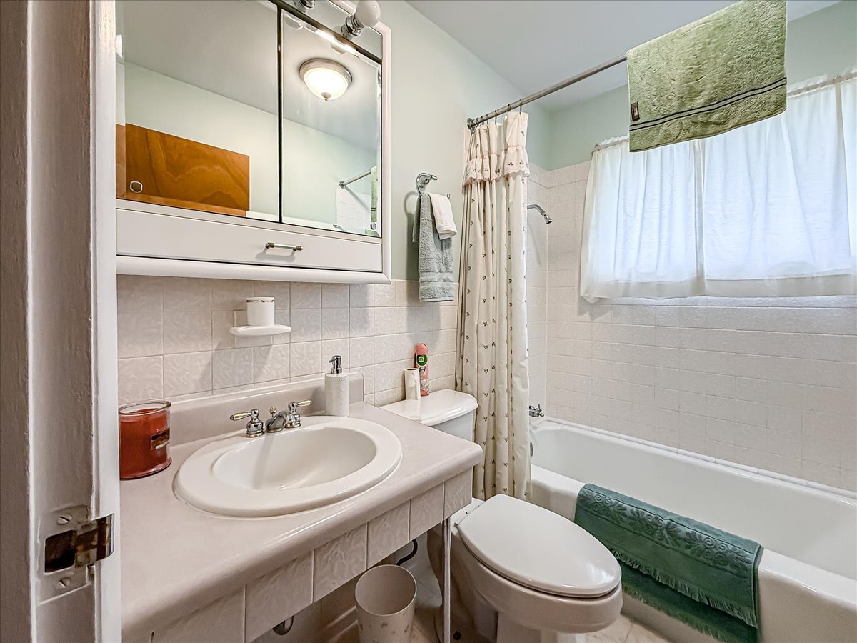 1612 Cornell Drive Champaign, IL 61821 - Photo 21 of 28 a bathroom with a sink toilet a mirror and shower