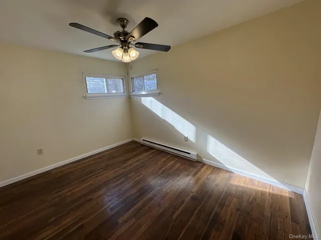 a view of wooden floor and a chandelier fan in a room