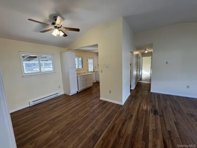 a view of a livingroom with wooden floor and staircase