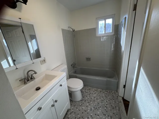 a bathroom with a sink a toilet a mirror and shower