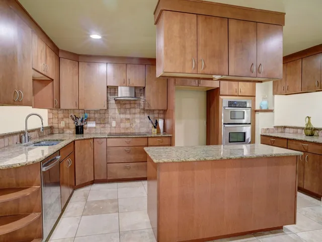 a kitchen with stainless steel appliances granite countertop a refrigerator sink and cabinets