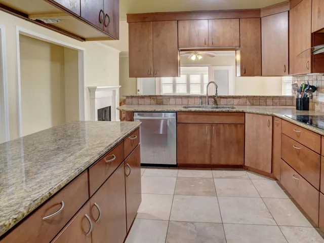 a kitchen with stainless steel appliances granite countertop a sink counter space cabinets and a large window