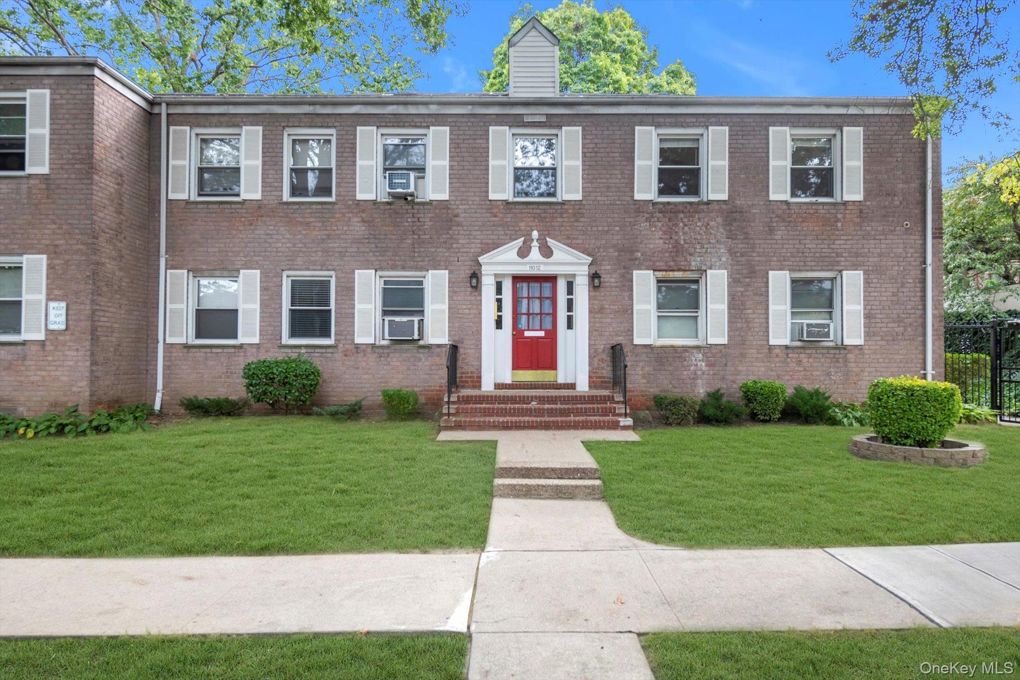 front view of a brick house with a yard