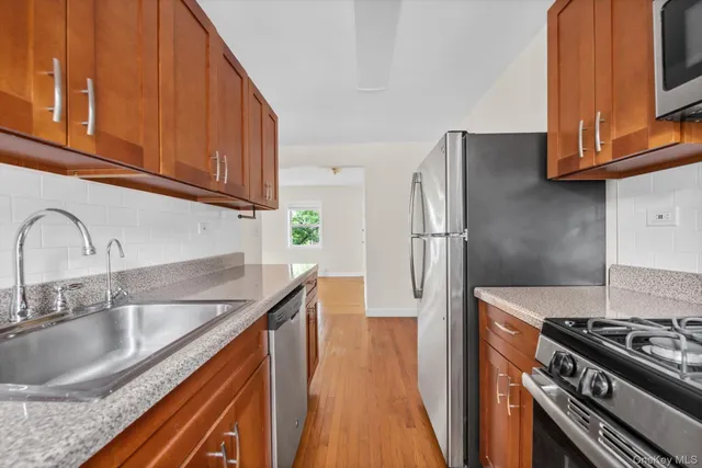a kitchen with granite countertop a sink stainless steel appliances and cabinets
