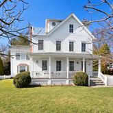 a view of a house with a big yard and large tree