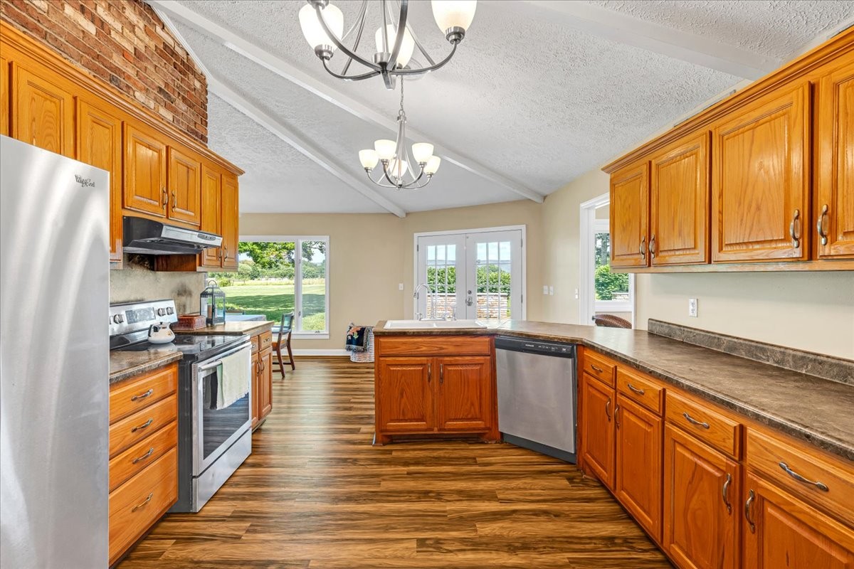 183 Prairie Plains Road Hillsboro, TN 37342 - Photo 12 of 63 a kitchen with stainless steel appliances granite countertop a stove top oven a sink dishwasher a dining table and chairs with wooden floor