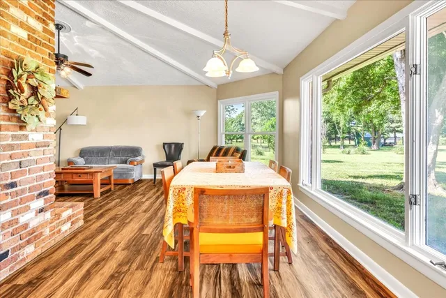 a dining room with furniture and a floor to ceiling window