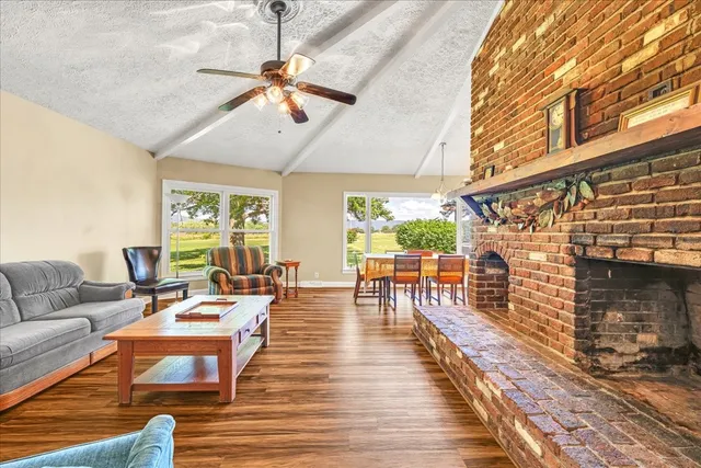 a living room with fireplace furniture and a large window