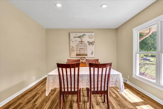 a dining room with furniture window and wooden floor