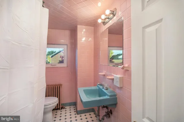 a bathroom with a sink toilet and a mirror