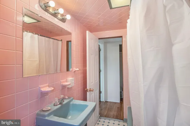 a bathroom with a sink a toilet and shower curtain