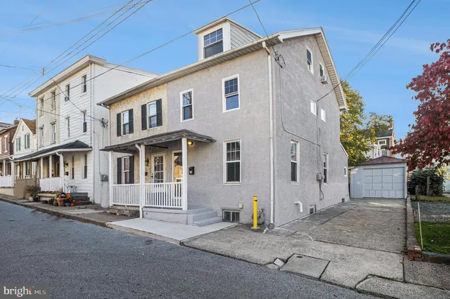 a view of a white house with a street