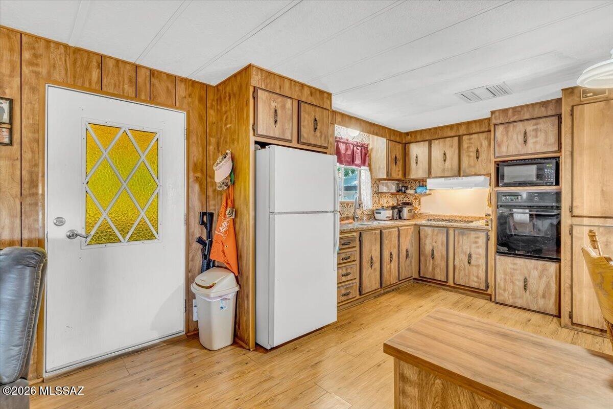 5379 West Rafter Cir Street Tucson, AZ 85713 - Photo 7 of 38 a kitchen with stainless steel appliances granite countertop a refrigerator a stove and a sink with wooden floor