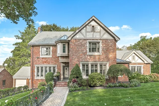 a front view of a house with a yard and potted plants