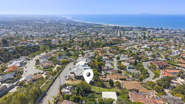 an aerial view of a house with a mountain