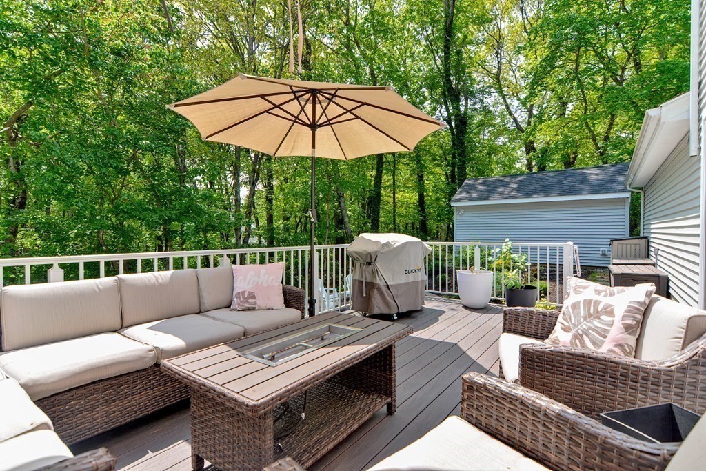 9 Woodcliff Road Canton, MA 02021 - Photo 14 of 42 a roof deck with a table and chairs under an umbrella