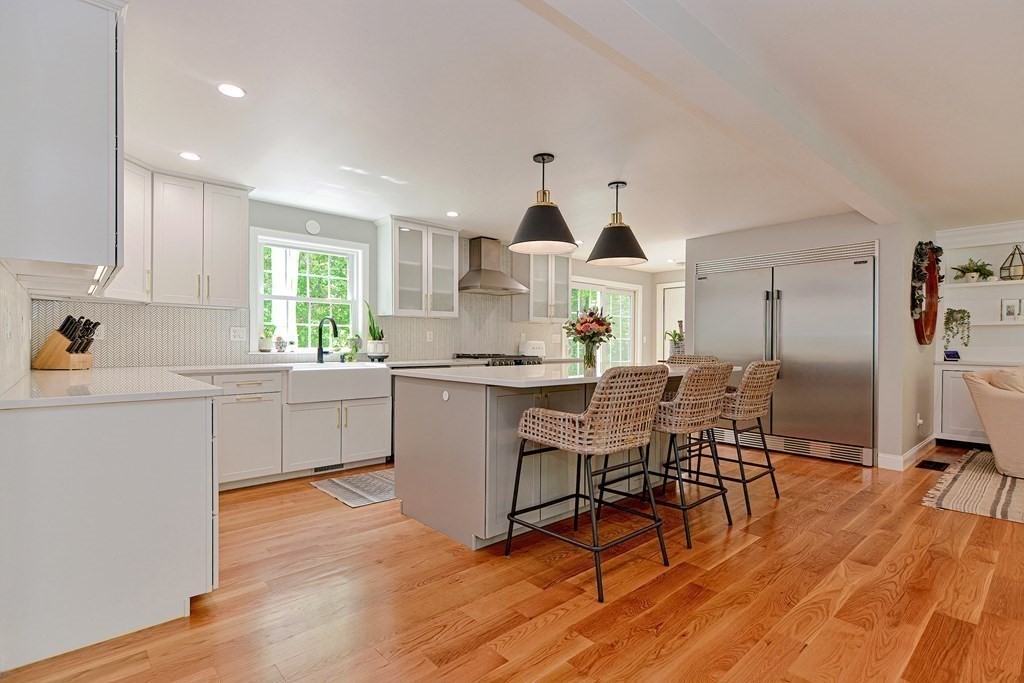 9 Woodcliff Road Canton, MA 02021 - Photo 8 of 42 a kitchen with kitchen island granite countertop wooden floors and white stainless steel appliances