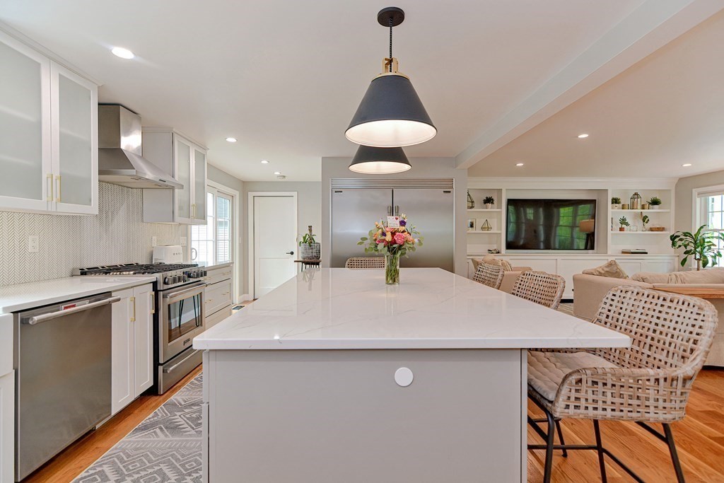 9 Woodcliff Road Canton, MA 02021 - Photo 9 of 42 a large kitchen with stainless steel appliances a dining table chairs and white cabinets