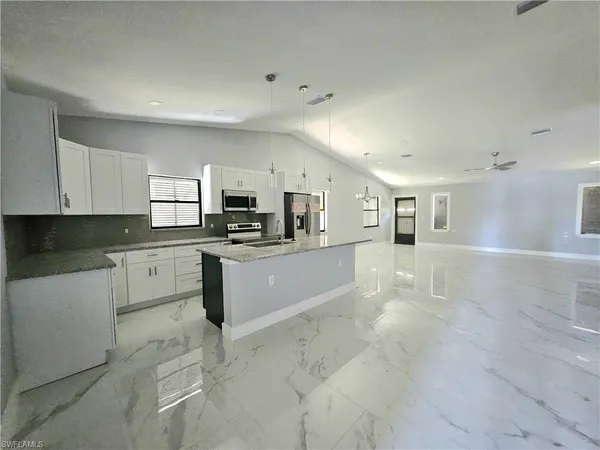 a large white kitchen with cabinets