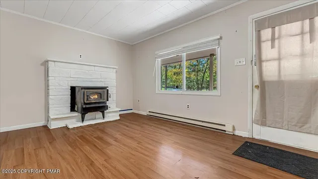an empty room with wooden floor fireplace and windows