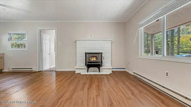 a view of a livingroom with wooden floor and a fireplace