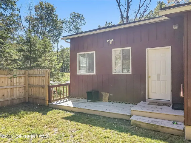 a view of a house with wooden floor and a small yard
