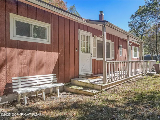 an aerial view of residential house with outdoor space and covered by trees
