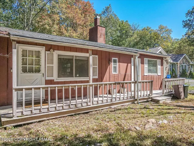 a view of a house with a small yard and wooden fence