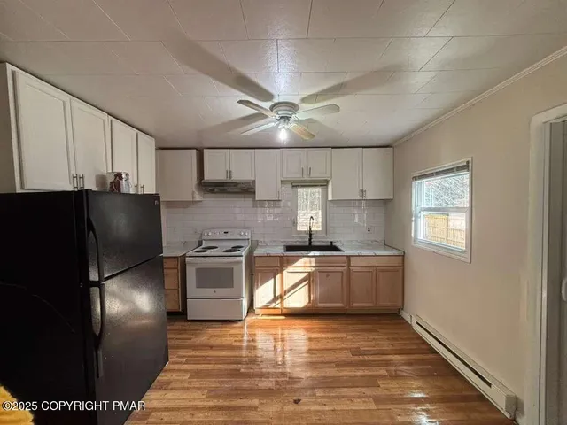 a kitchen with stainless steel appliances granite countertop a refrigerator a stove a sink and a microwave