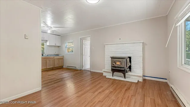 an empty room with wooden floor a fireplace and windows