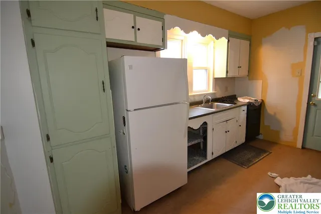 a kitchen with granite countertop a sink stove and refrigerator