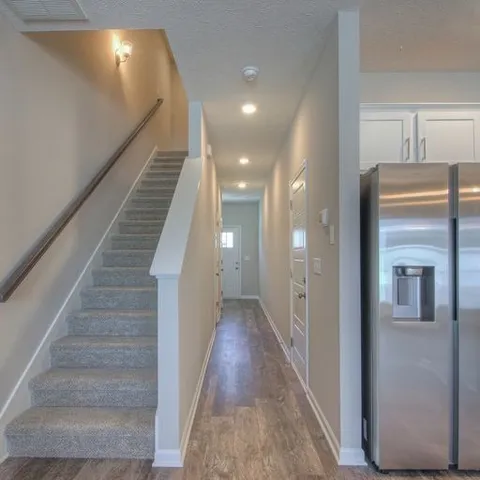 a view of a hallway with wooden floor and staircase