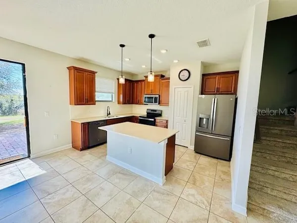a kitchen with stainless steel appliances granite countertop a refrigerator and a stove top oven
