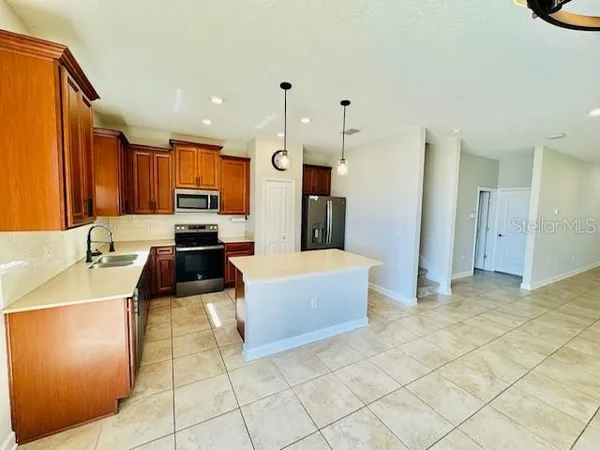a kitchen with stainless steel appliances a stove a sink a refrigerator and cabinets