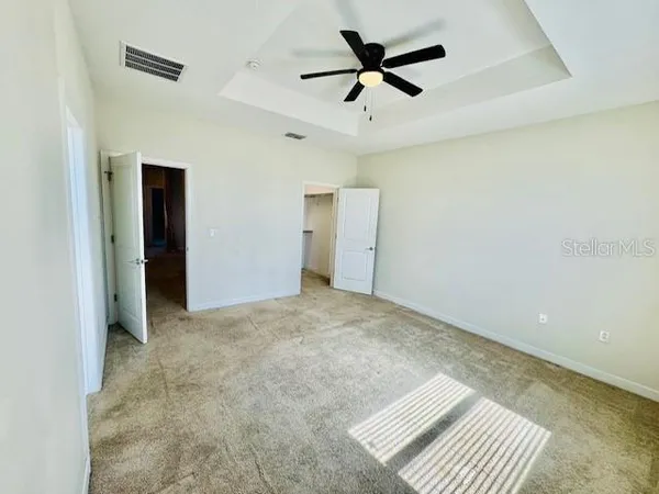 an empty room with a ceiling fan and a window