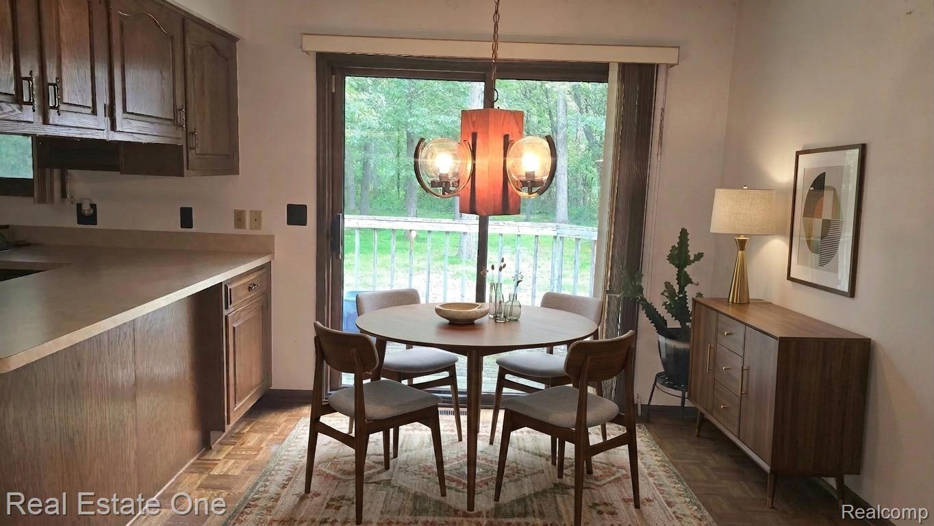 8950 Wise Road Commerce Township, MI 48382 - Photo 5 of 39 Dining area featuring a wood-finish floor, a sliding glass door, and a decorative overhead light fixture
