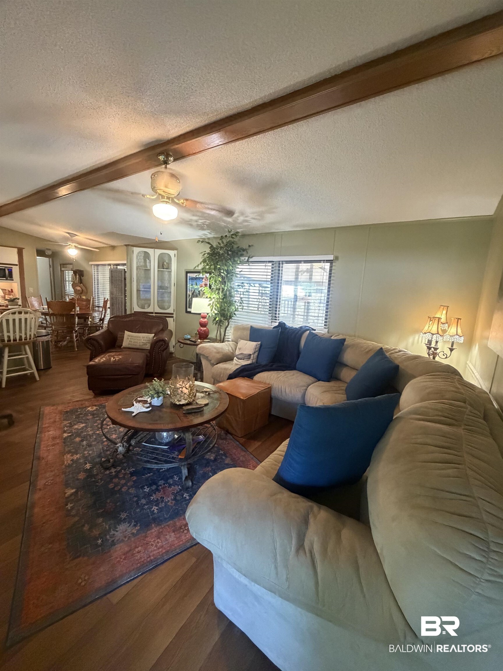 1620 Del Rey Drive Lillian, AL 36549 - Photo 10 of 45 Expansive living area featuring wood-finish flooring, a ceiling fan, and decorative exposed ceiling beams