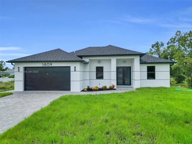 a front view of a house with a garden and yard