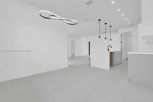 a kitchen with kitchen island a sink a stove and a large window