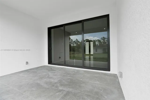 a view of an empty room with a cabinet and mirrors