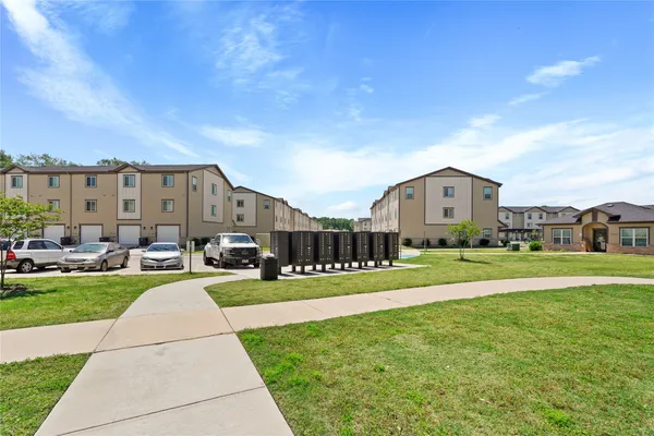a view of a big house with a big yard and large trees