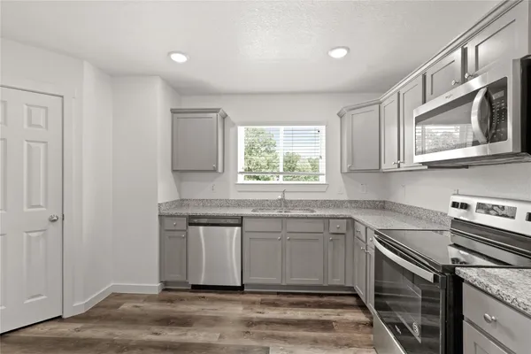 a kitchen with stainless steel appliances granite countertop a sink stove and microwave