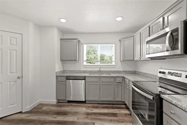a kitchen with stainless steel appliances granite countertop a sink stove and microwave
