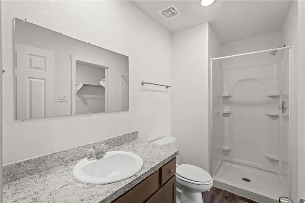 a bathroom with a sink toilet a mirror and shower