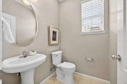 a bathroom with a toilet a sink and mirror