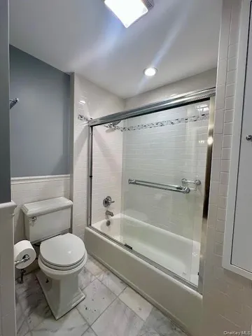 a bathroom with a toilet and a shower