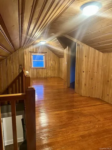 an empty room with wooden floor windows and ceiling fan