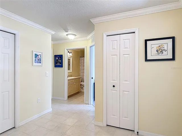 a view of a hallway with closet and a bathroom
